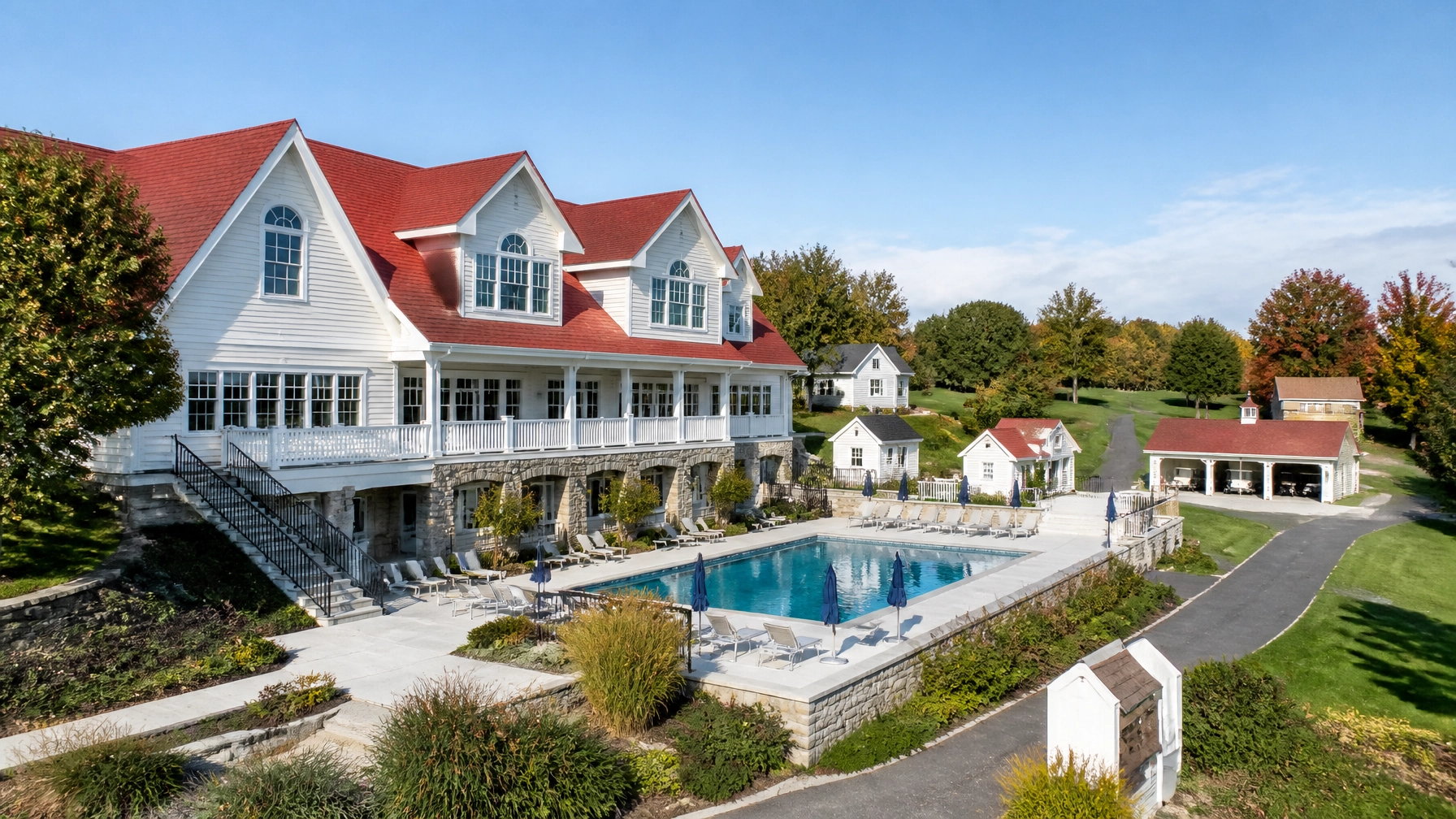 Clean golf club property with restored clubhouse, patio, walkways, pool house, and cart barn